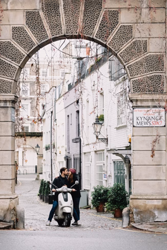 a couple on a scooter in a narrow street