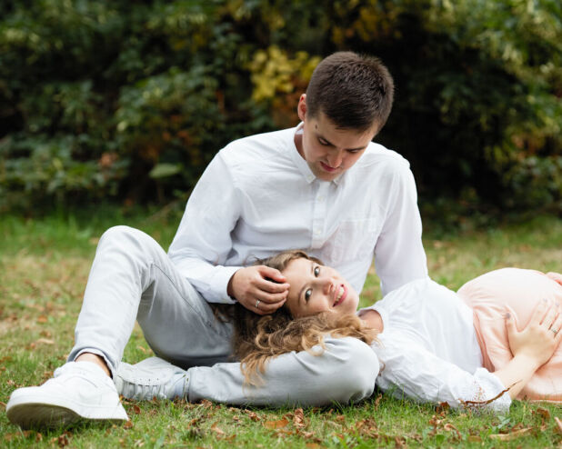 a man and woman laying on the grass