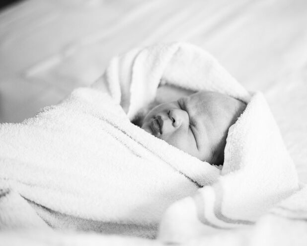 a baby wrapped in a blanket on a bed