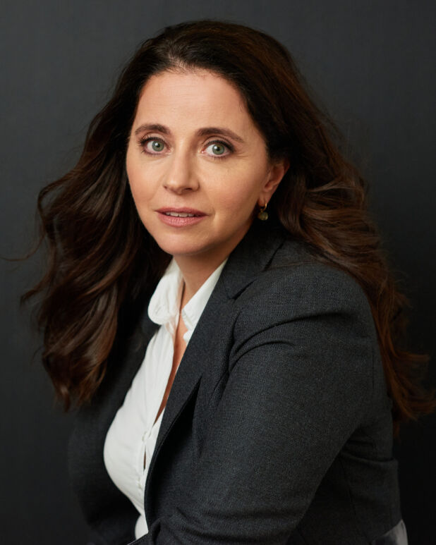 a woman with long hair and a suit jacket